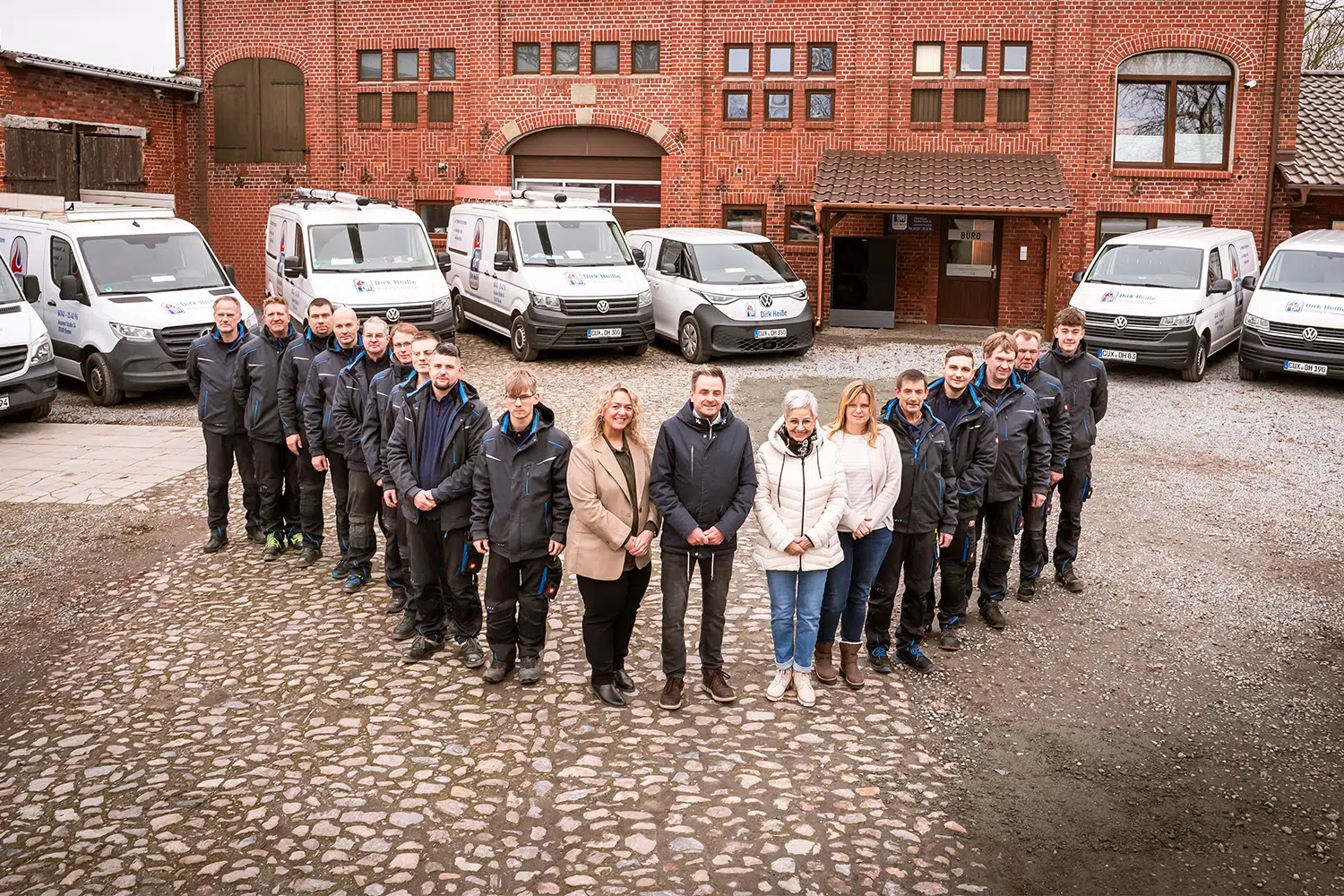 Heisse-Mitarbeiter-Gruppenbild-vor -Firmengelaende Gruppenbild vor Firmengebäude
