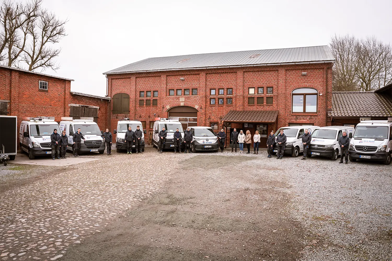 Heisse-Mitarbeiter-Gruppenbild-vor-Firmengebaeude-mit Firmenwagenflotte Heisse Mitarbeiter Gruppenbild vor Firmengebaeude